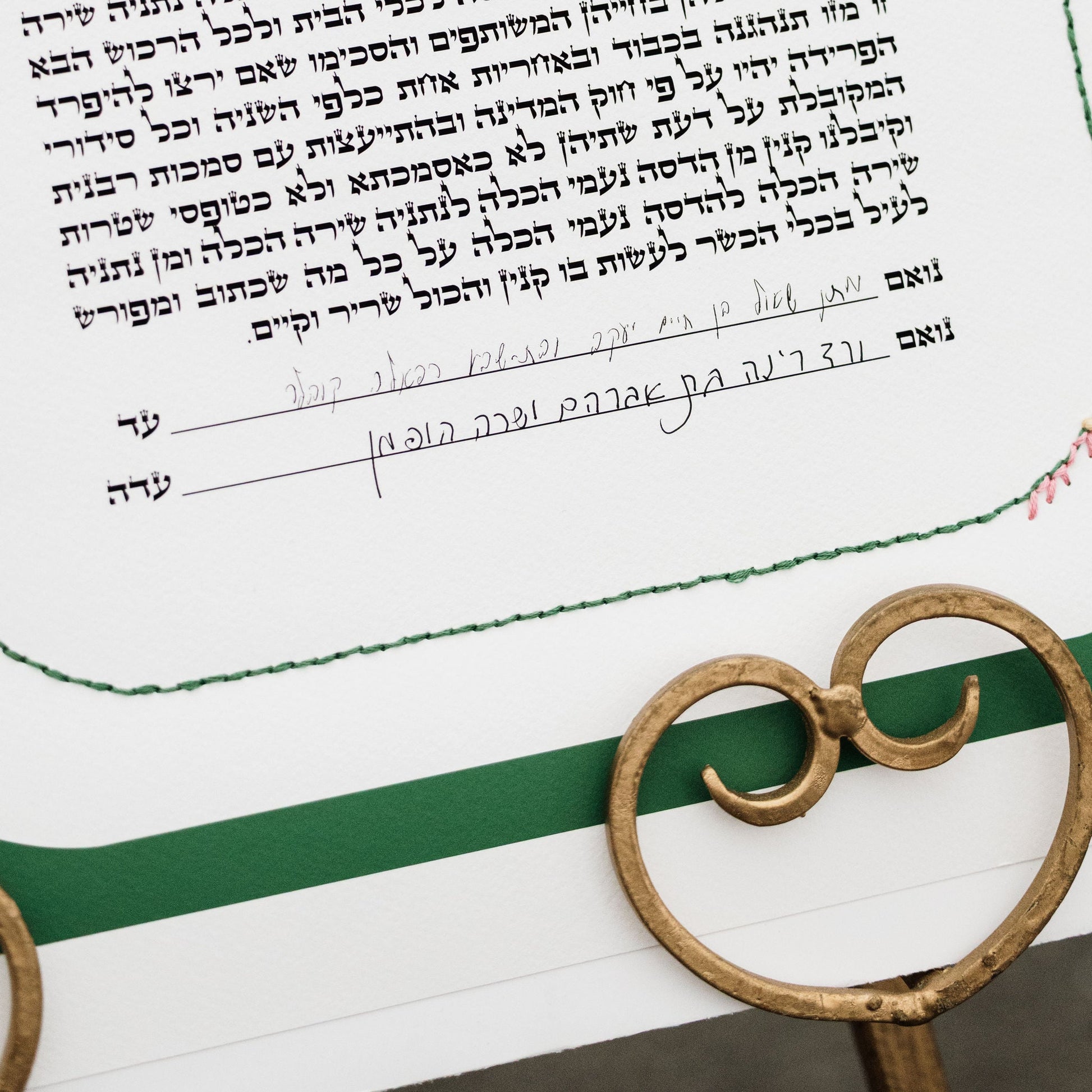 A close-up of a printed ketubah  with handwritten signatures 